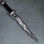 the dark Detailed close-up of the "Dark One" name engraving on the 30 cm wooden Rumpelstiltskin dagger with weathered silver finish.